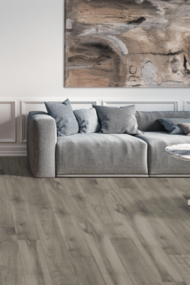 grey toned laminate flooring with grey couch and white walls